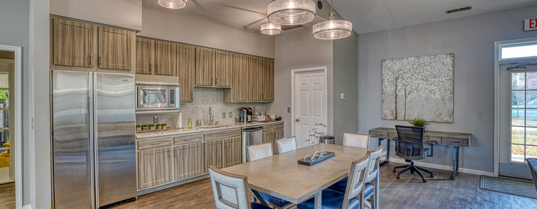 Resident clubhouse kitchen and dining area with seating and workspace at Mill Pond Village in Salisbury, Maryland