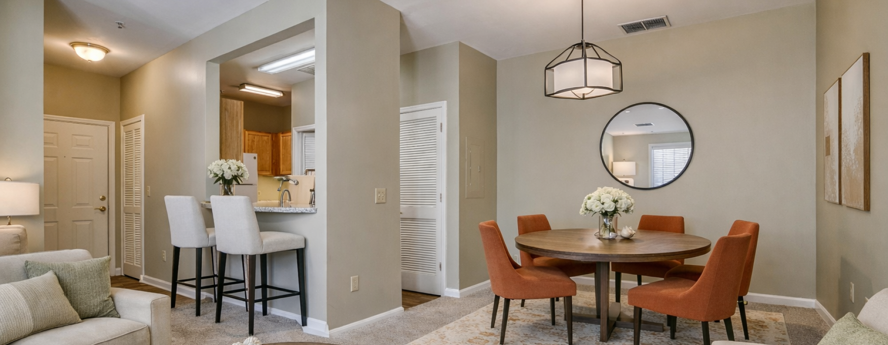 Virtually staged model apartment featuring a warm modern transitional living and dining area with round dining table and contemporary furnishings at Mill Pond Village in Salisbury, Maryland